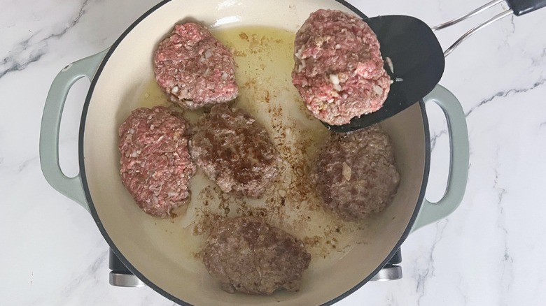 cooking steak patties in skillet