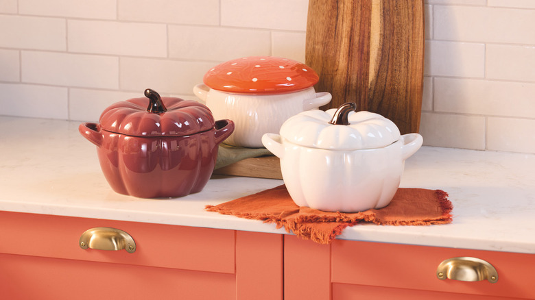 Three small pumpkin-shaped casserole dishes on kitchen counter