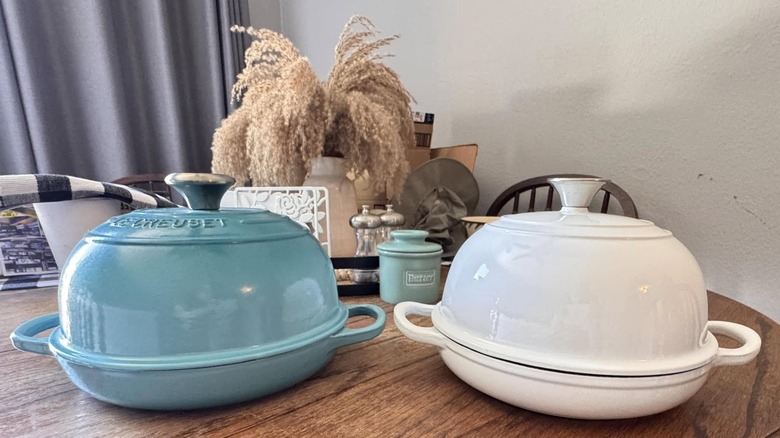 Blue Le Creuset bread dome next to white off-brand version