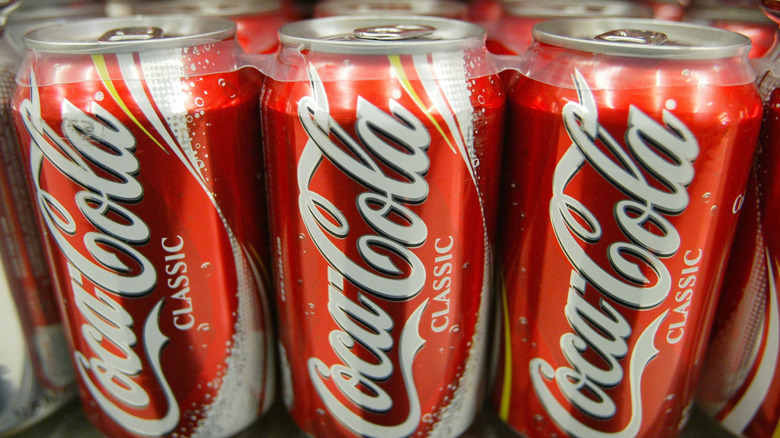 Three cans of classic Coca-Cola held together with a palstic ring