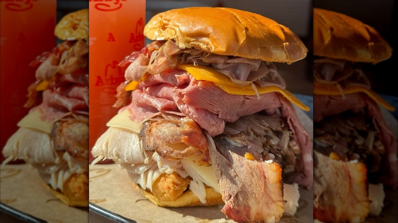 Arby's Meat Mountain sandwich on platter with drink in the background