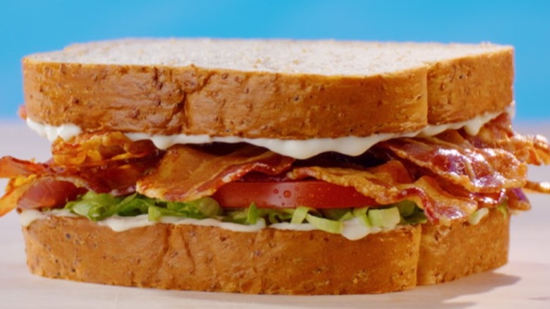 Ultimate BLT sandwich from Arby's on blue background