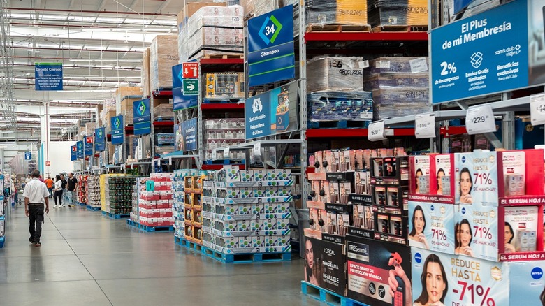 aisles at a Sam's Club store with shoppers walking through