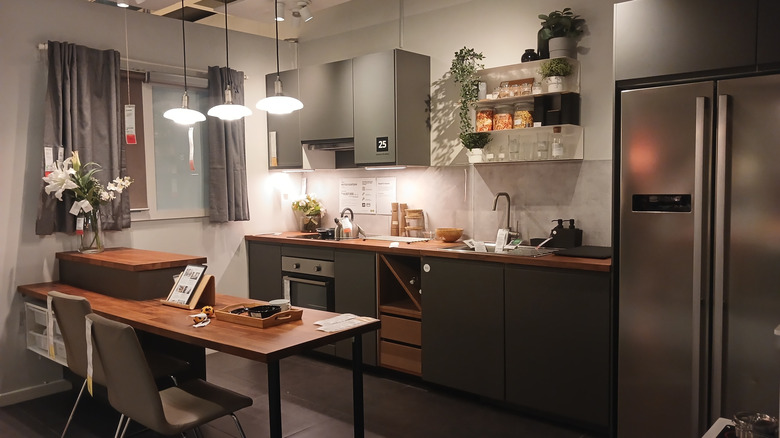 Modern IKEA kitchen showroom with gray cabinets and brown wood countertops