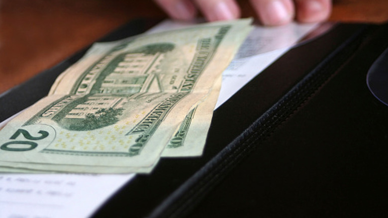 Several bills are left as a tip in a restaurant