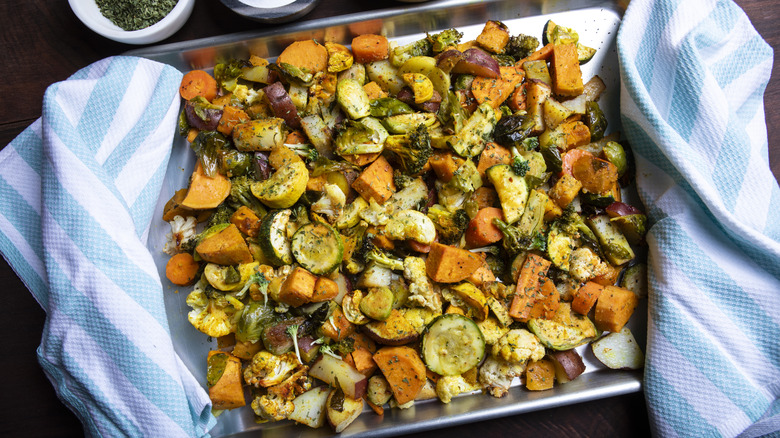 A tray of roasted vegetables resting on a blue striped towel