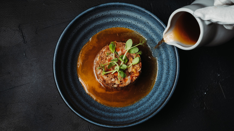 Sauce is poured onto a meat dish