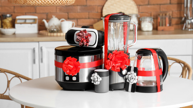 Various kitchen appliances wrapped in red ribbons with bows
