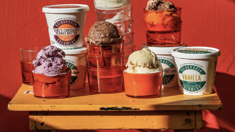 pints of adirondack creamery ice cream, scoops of ice cream in red glasses, stacked against a red background