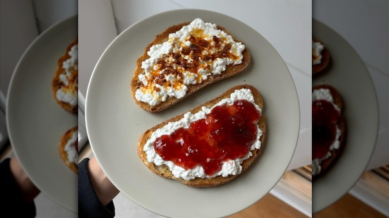 Two pieces of cottage cheese toast on a plate, one with chili crisp and one with jam