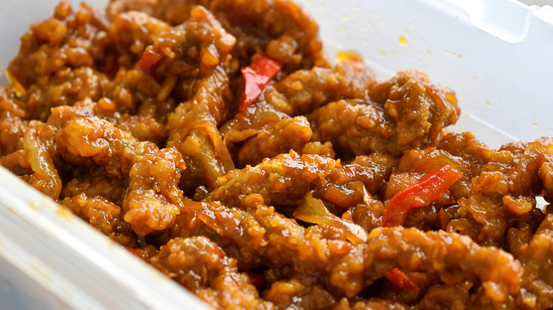 Crispy shredded beef in a white container