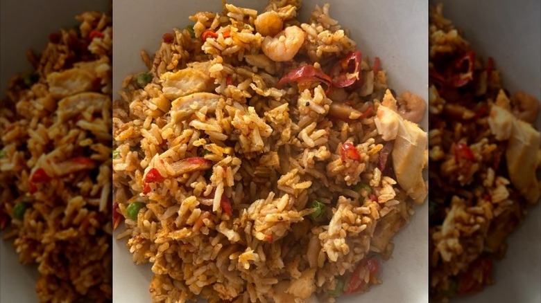 Singapore fried rice with chicken and prawns on a white plate