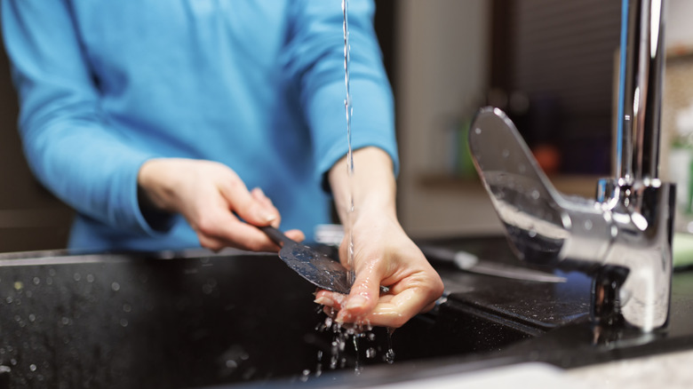 A woman washing a palette knife