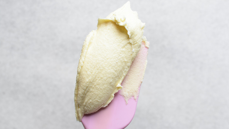 Buttercream frosting on a pink silicone spatula