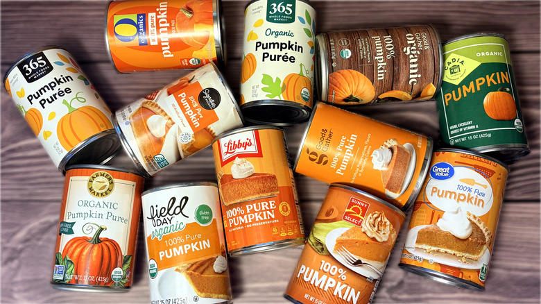 Various brands of canned pumpkin scattered on a table