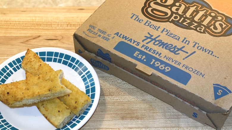 Mr. Gatti's Pizza box next to a small plate of breadsticks