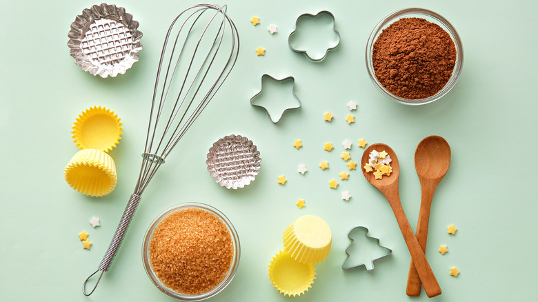 Baking tools and ingredients on a mint green backdrop
