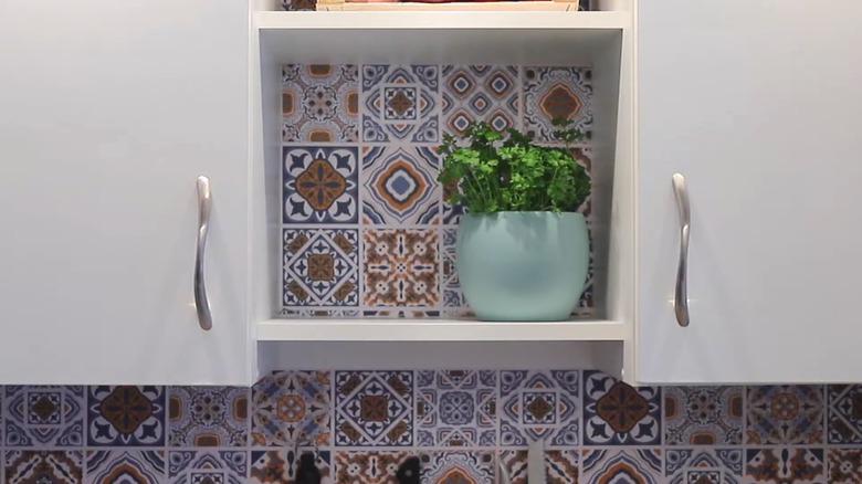 View of contact paper used to fill empty wall space between and inside cabinets