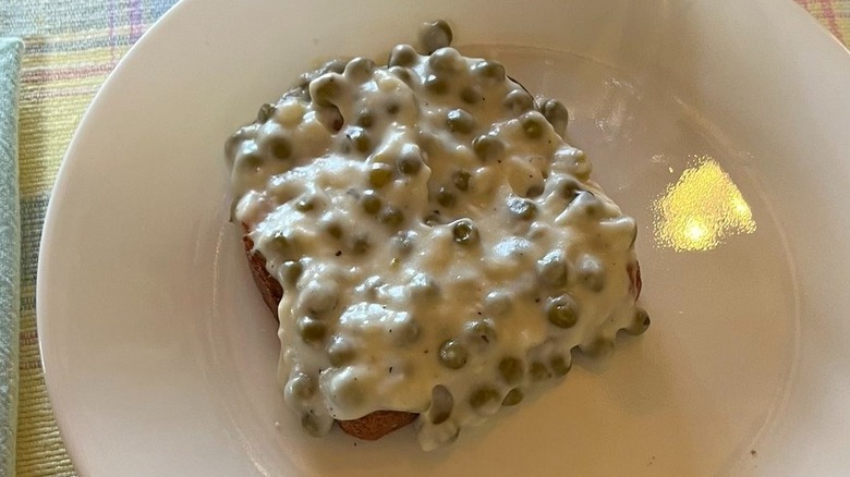 Slice of creamed peas on toast on a white plate