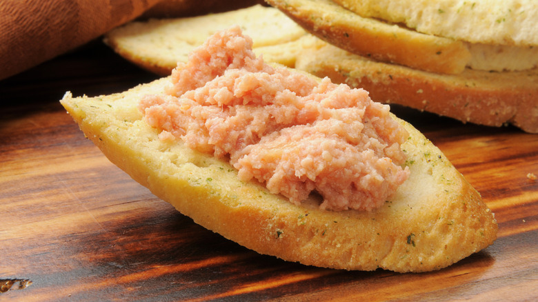 Deviled ham on toast sitting on a wooden counter