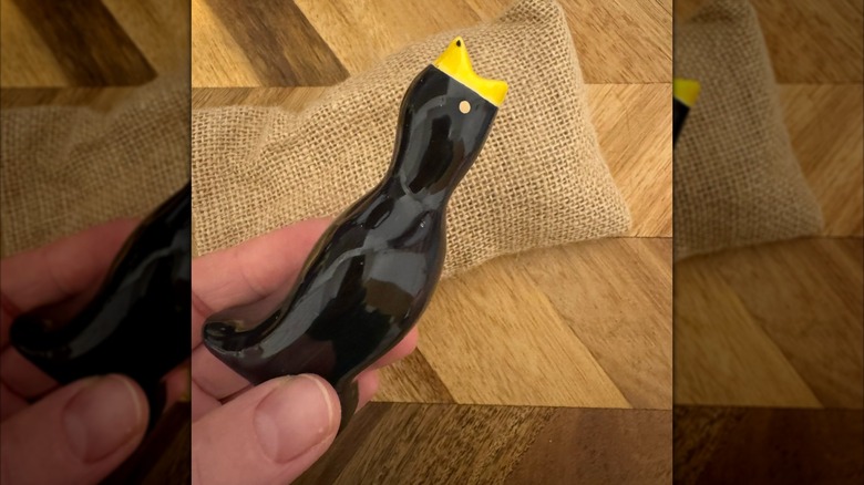 A hand holds a ceramic pie bird