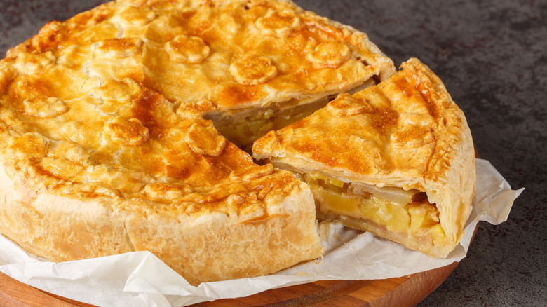 Old-school onion pie placed on a parchment paper over a wooden board