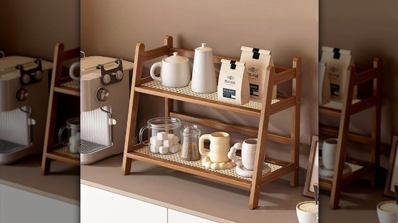 Bamboo two tier organizer on counter with coffee bags, a jar with sugar cubes, mugs, and canisters on it.