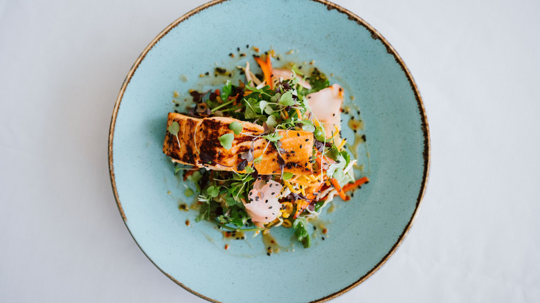 An overhead view of a gourmet dish of salmon and vegetables