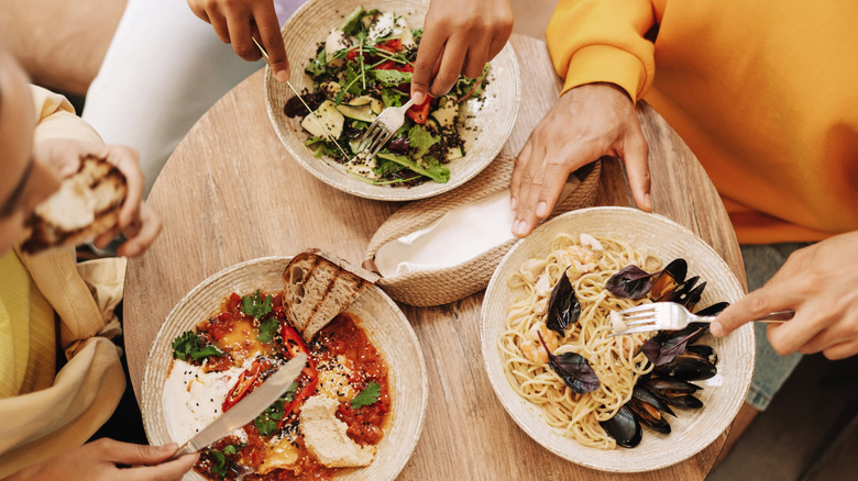 An overhead view of friends sharing food in a restaurant