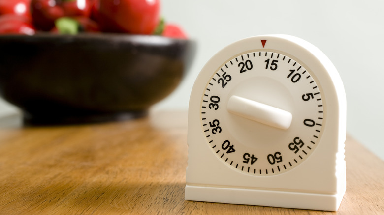 A kitchen timer in selective focus on a wooden table