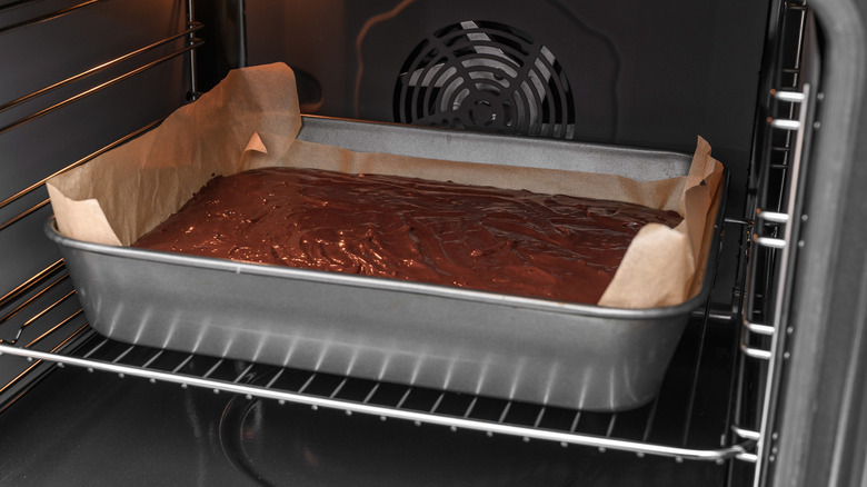 A pan full of brownie batter in an oven