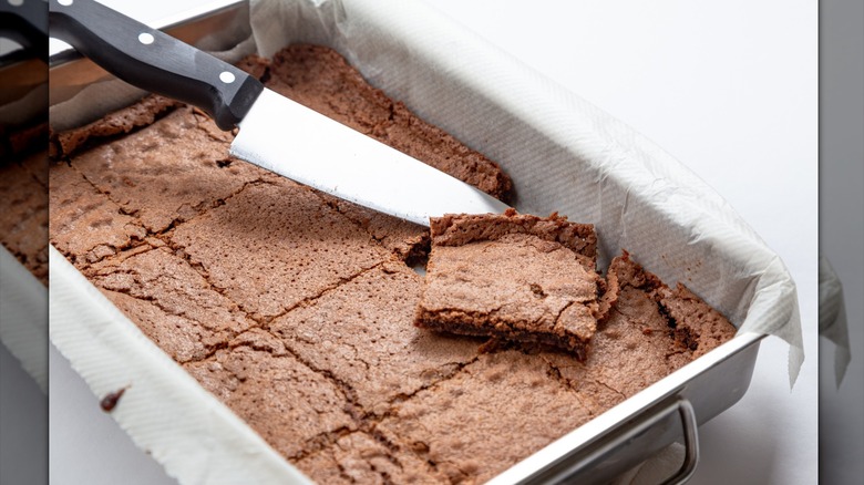 Overly thin brownies in a flat pan with a knife