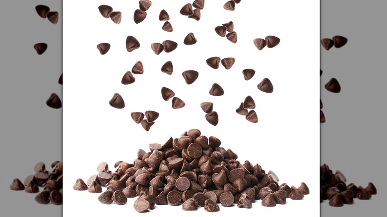A pile of chocolate chips on a white table with a white background