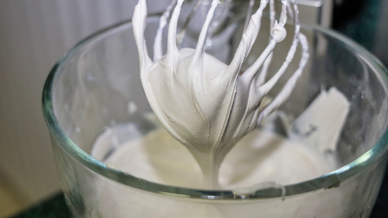 Royal icing in a mixing bowl of a stand mixer with a whisk