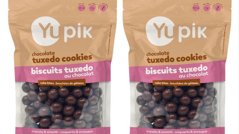 Two packets of of Yupik tuxedo cookies side by side, with packaging in beige with a pink stripe