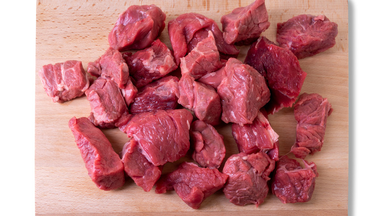 Chunks of raw beef on cutting board