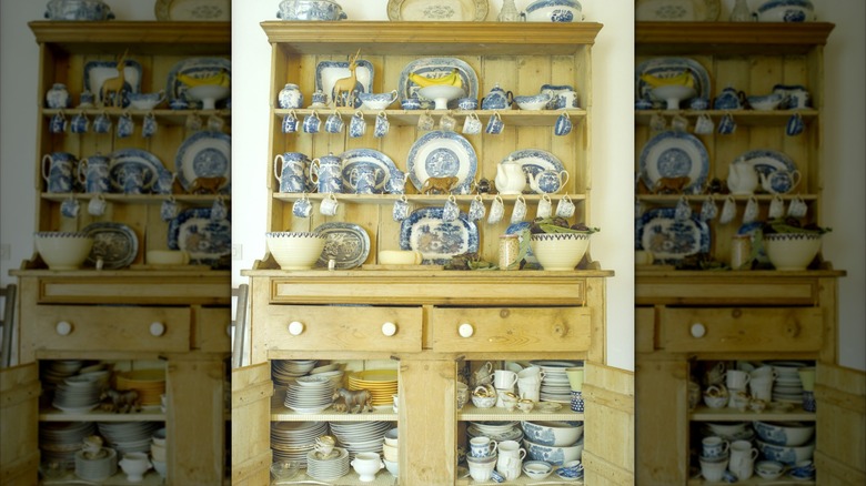Light wood hutch with blue and white dishes.