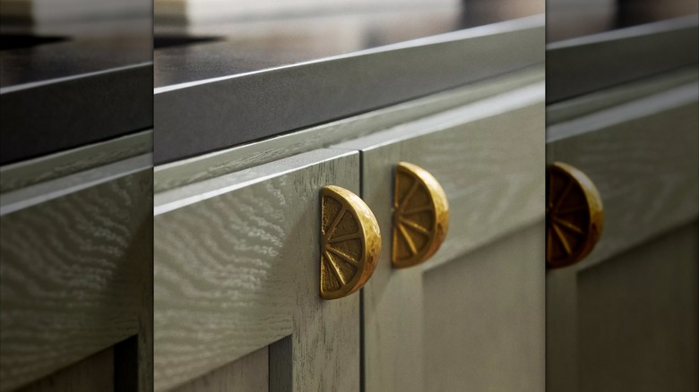 Gold colored lemon shaped cabinet handles.