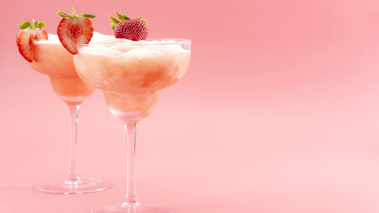 Two strawberry cocktails on a pink table