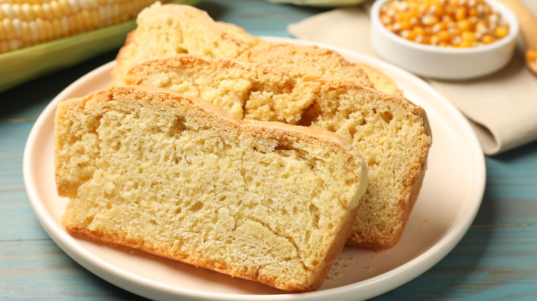 Cornbread slices on a white plate placed on a blue table