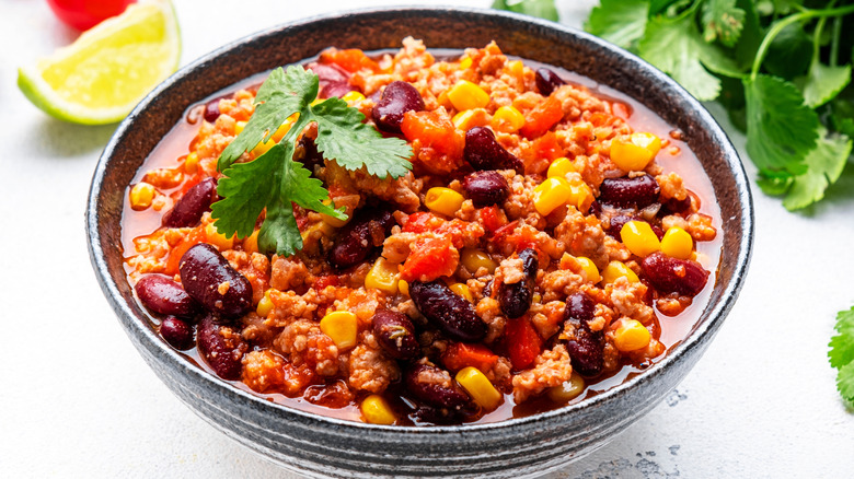 A bowl full of hearty American chili on a white table