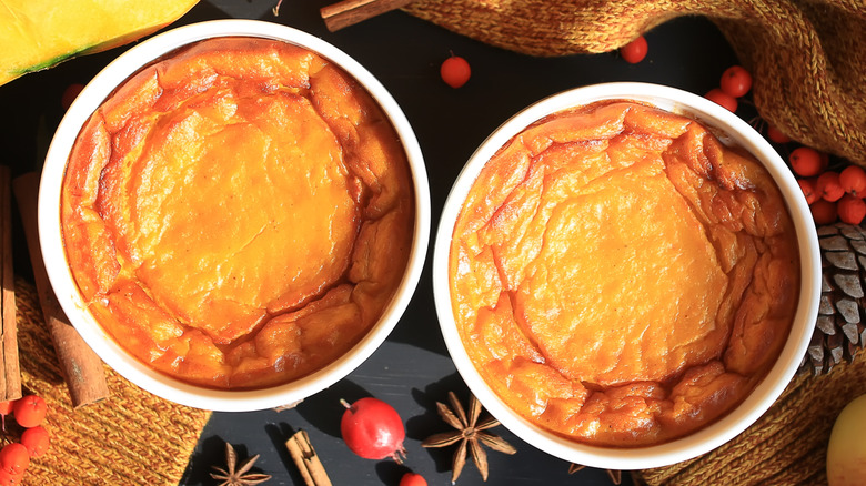 Pumpkin soufflés on a black table with spices and berries