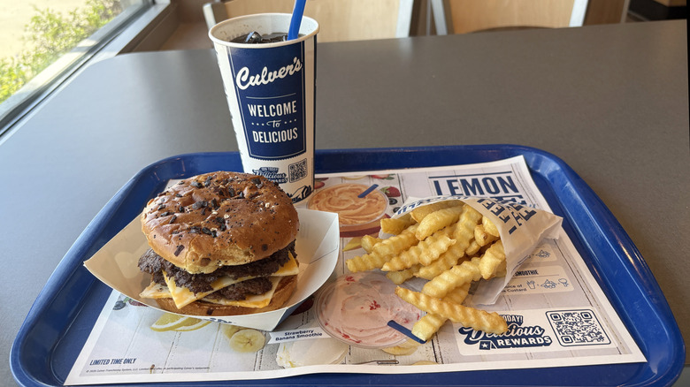 A butterburger, crinkle cut fries, and beverage from Culver's on a tray