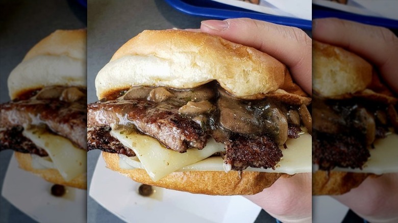 A person holding a Mushroom & Swiss ButterBurger from Culver's