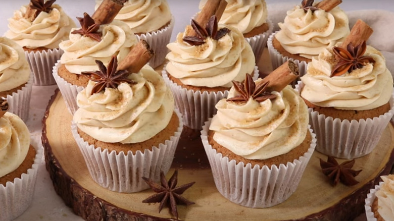 Chai tea cupcakes with cinnamon sticks and star anise on a log-shaped platter
