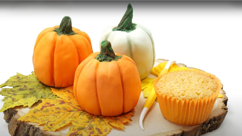 Two cupcakes transformed into tiny, edible pumpkins