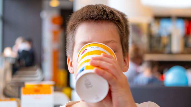 A child drinks from a McDonald's cup in one of its restaurants