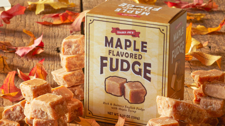 A package of Trader Joe's Maple Flavored Fudge on a wood table surrounded by candies and leaves