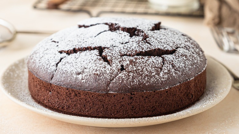 A round chocolate cake with powdered sugar