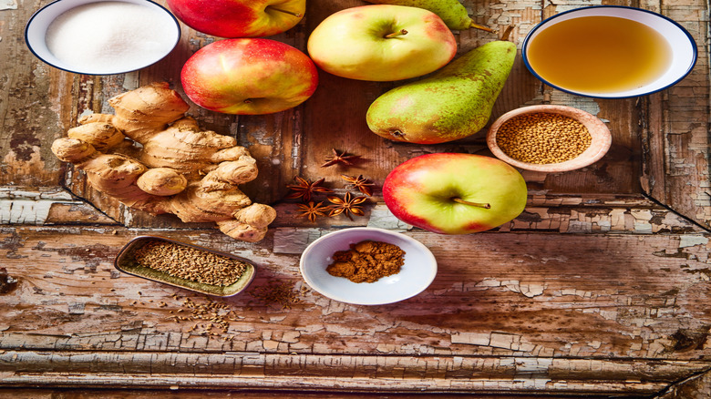 Apples and pears on a wooden table with a bowls on each side